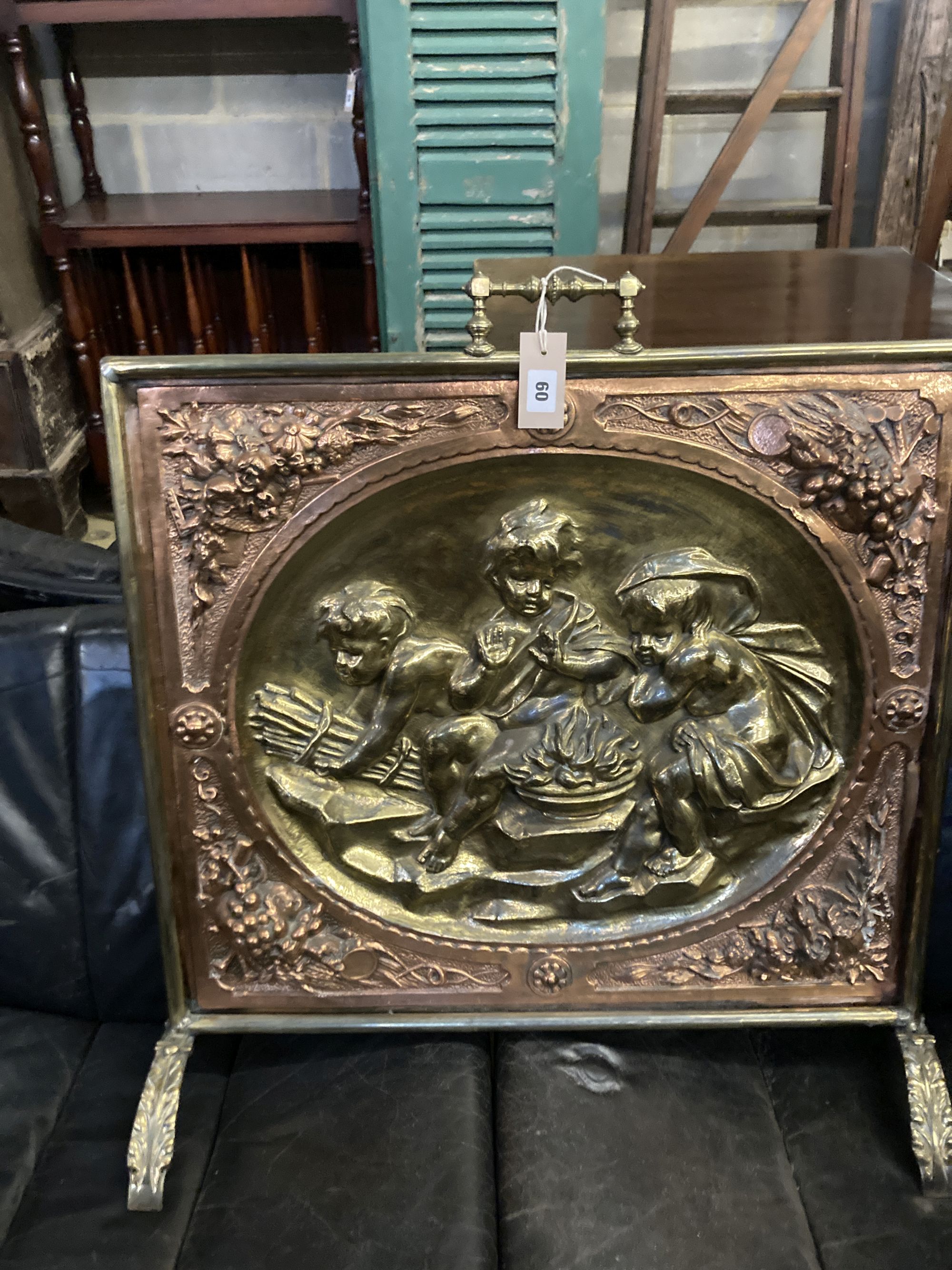 A embossed brass and copper fire screen, 70 x 70cm, together with a pierced brass fender